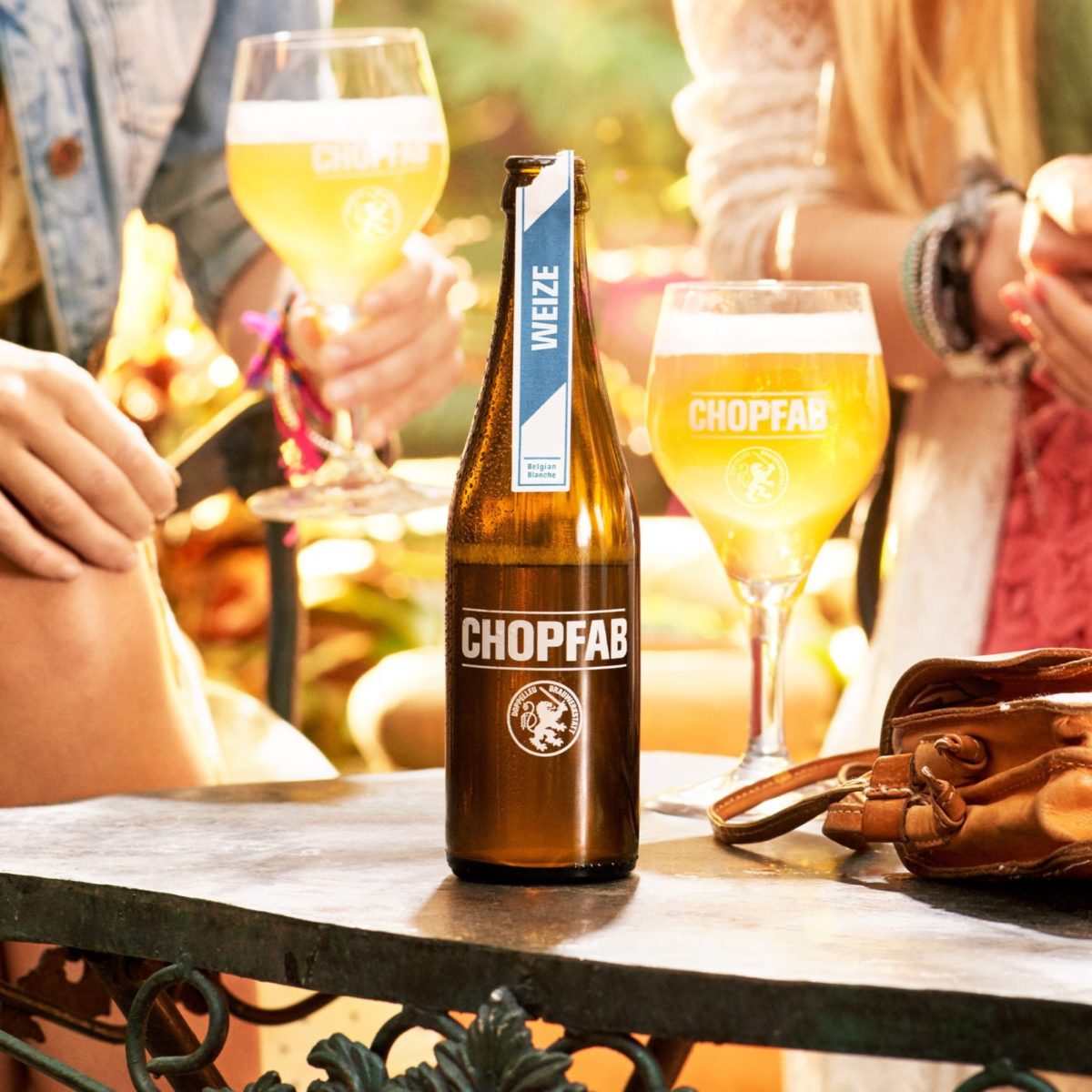 Zwei Freundinnen geniessen ein Chopfab Weize als Feierabendbier in einem Garten
